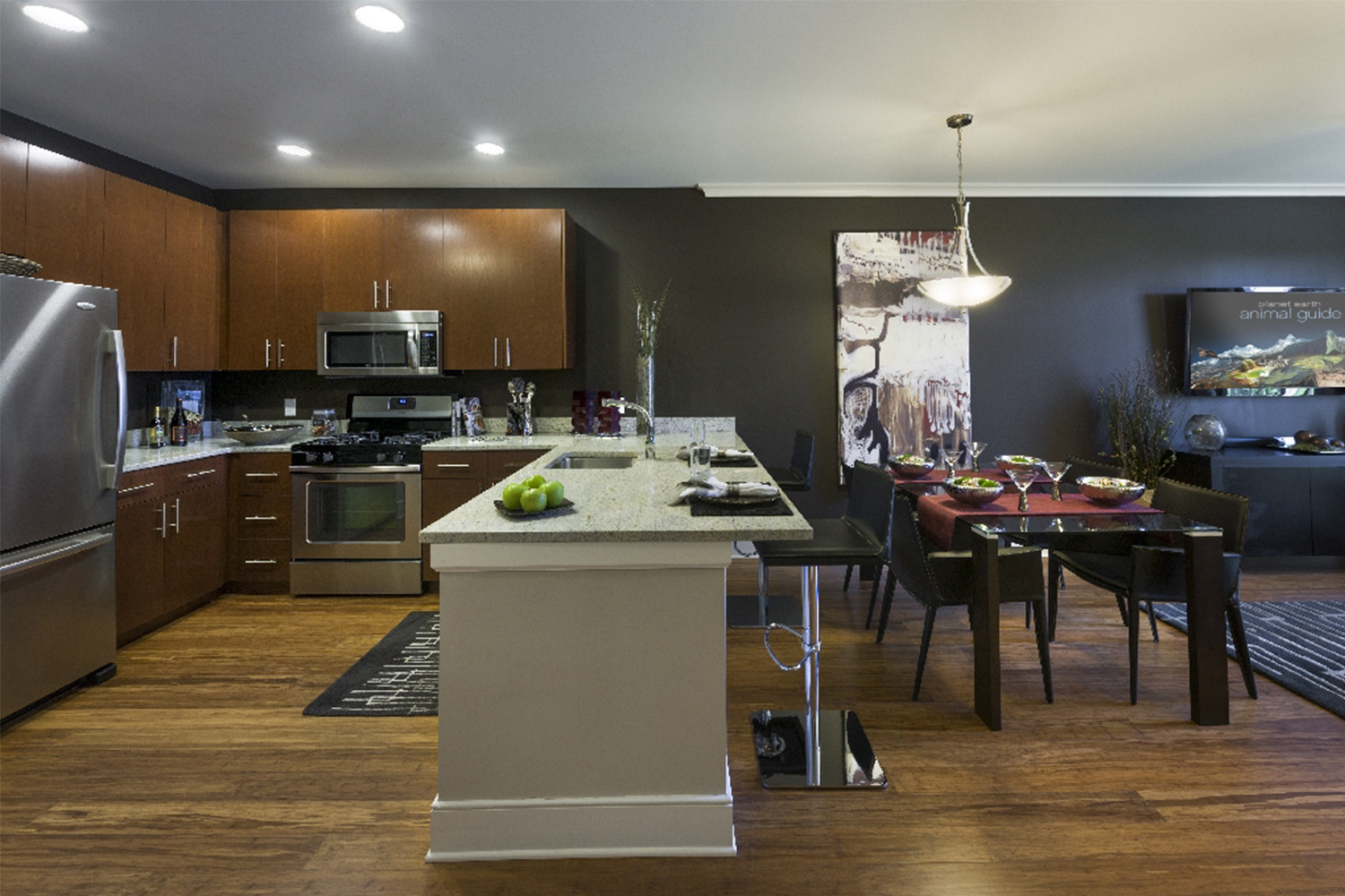 Sleek kitchen with wooden cabinets and white marble countertops, next to dining area