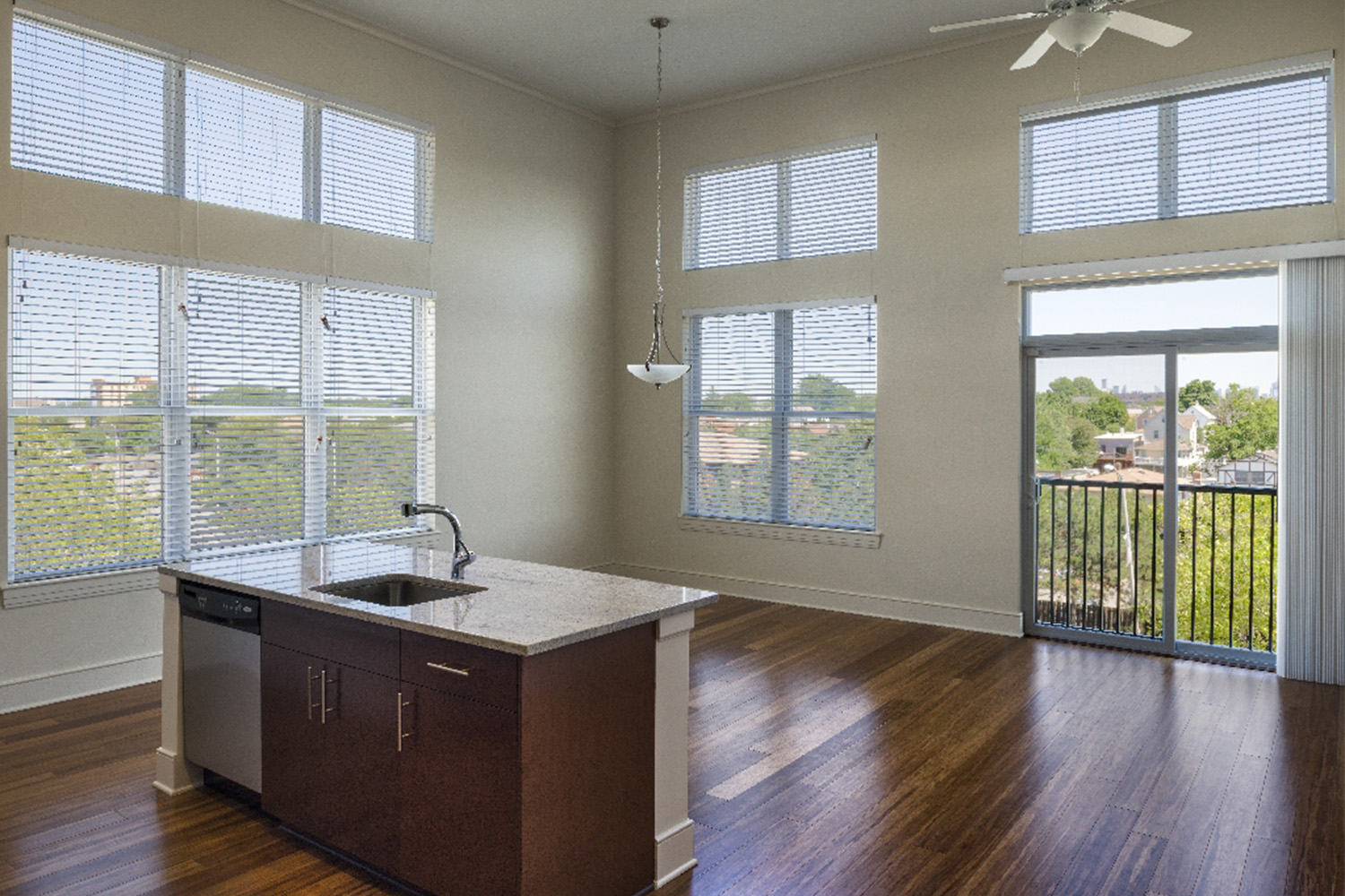 Spacious living area with ample lighting, and an island with a sink