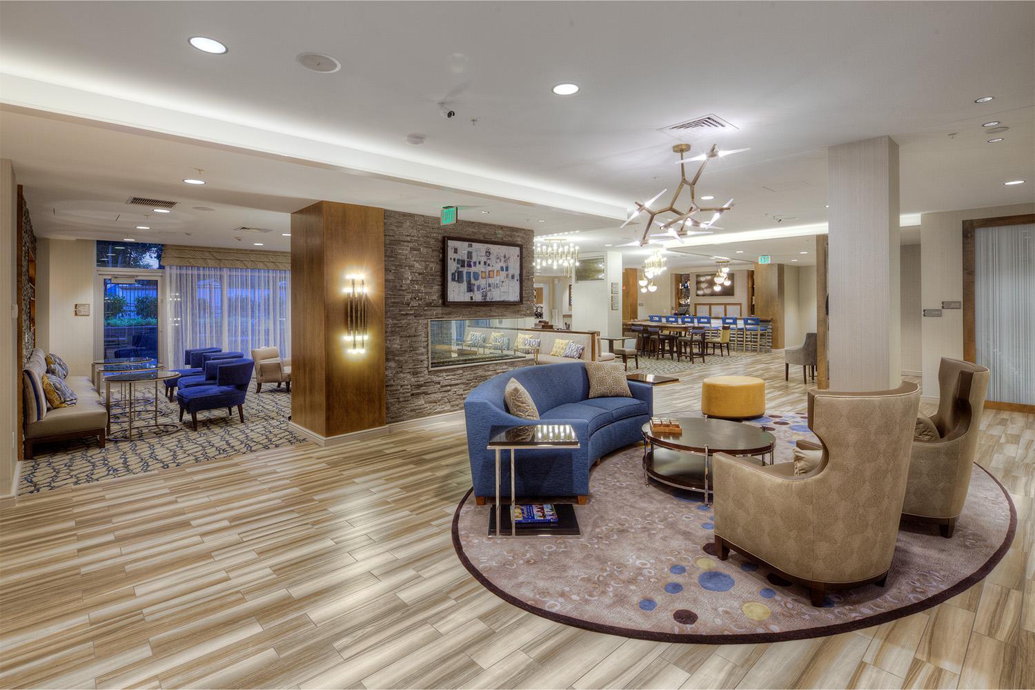 Lobby area with modern lighting fixtures, seating, and TV 