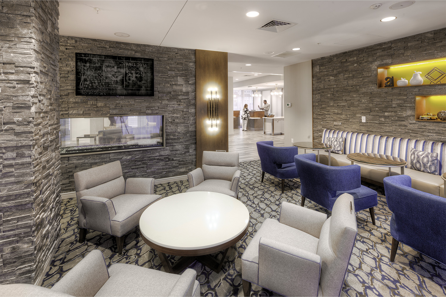 Lounge area with stone walls, and plush couches and chairs 