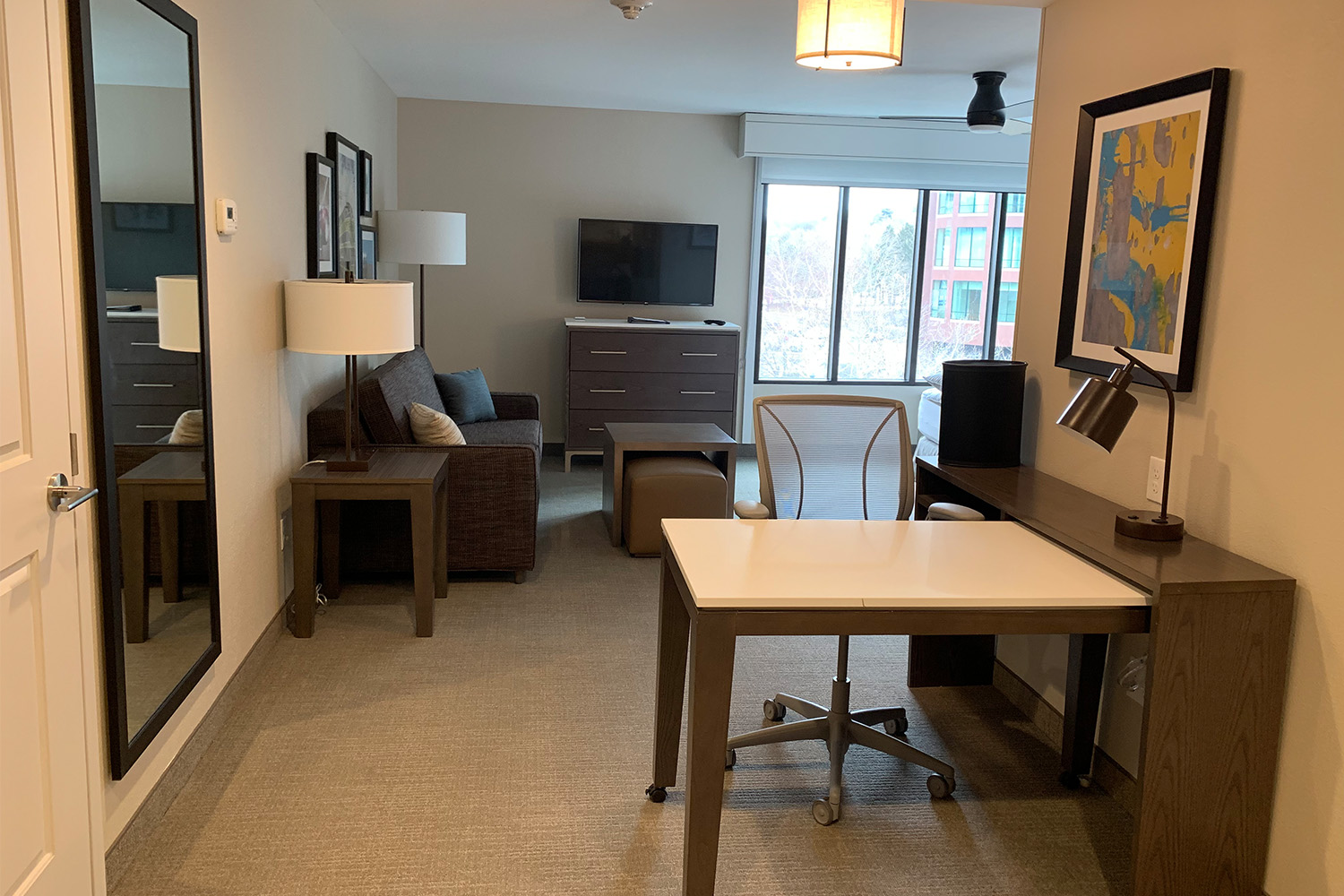 Quaint kitchen and dining area next to TV/lounge area, with bedroom in the back 