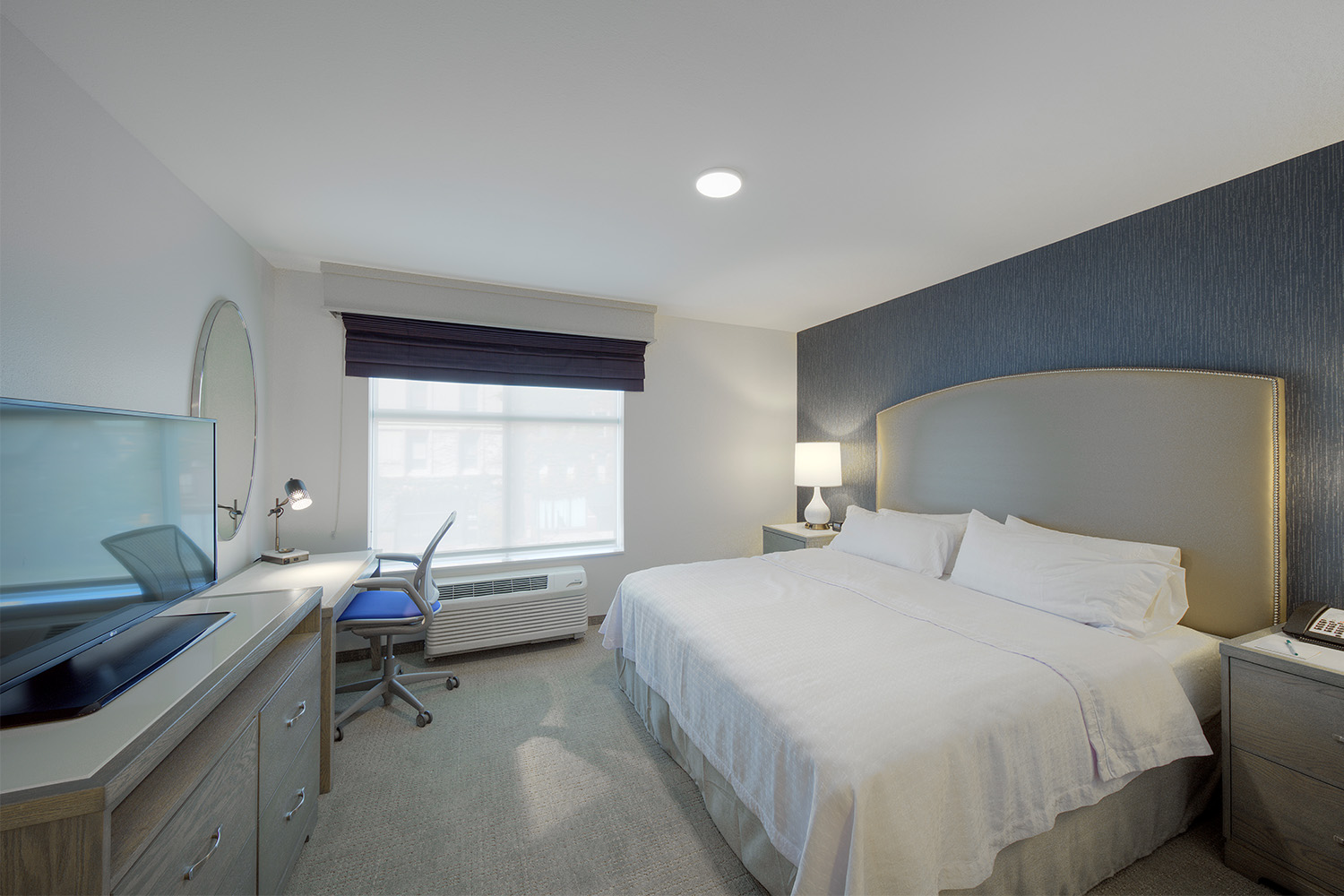 Ambient bedroom with soft bed, TV, and wide window