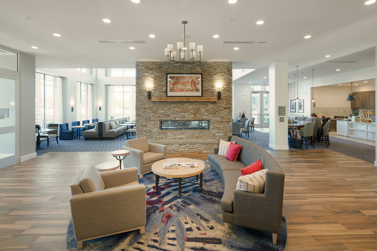 Lobby with fireplace and couches, next to café area 