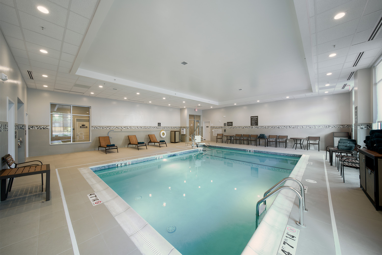 Indoor pool area with lounge chairs 