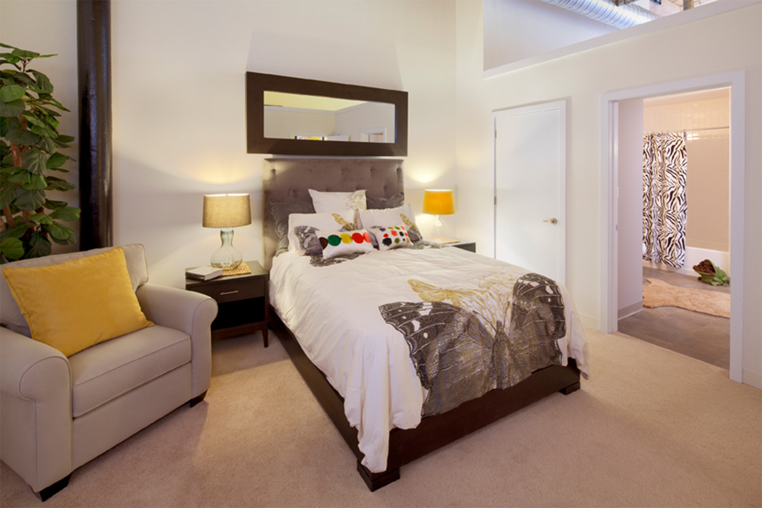 Bed with butterfly design, next to plush tan chair