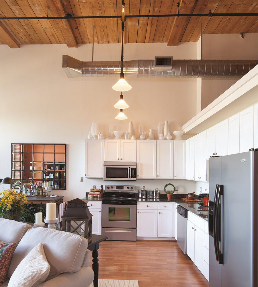 Kitchen with white cabinets, stovetop, microwave, and dual-refrigerator