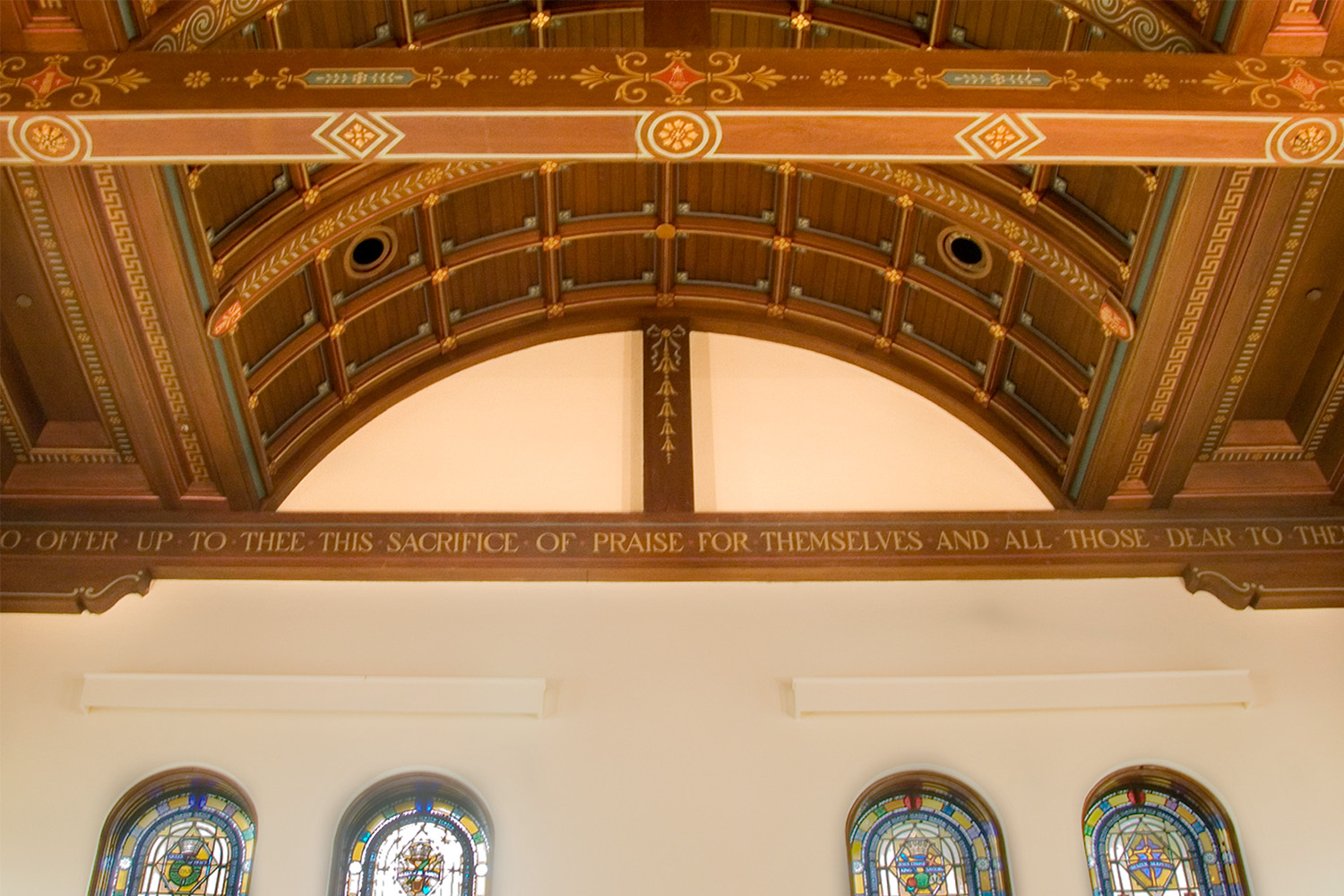 Zoomed-in view of woodwork detailing in chapel ceiling with holy scripture engraved 
