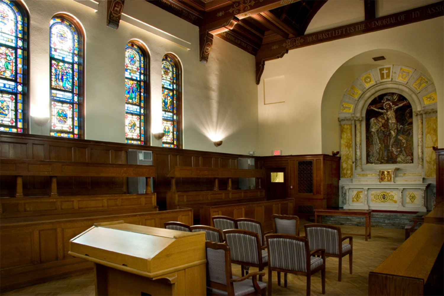 Light shining through stained glass windows in chapel, with view of the alter 