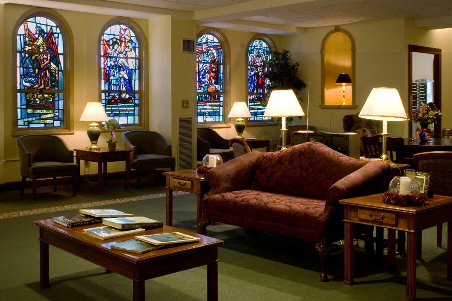 Lobby area with vintage red couch and stained glass windows 