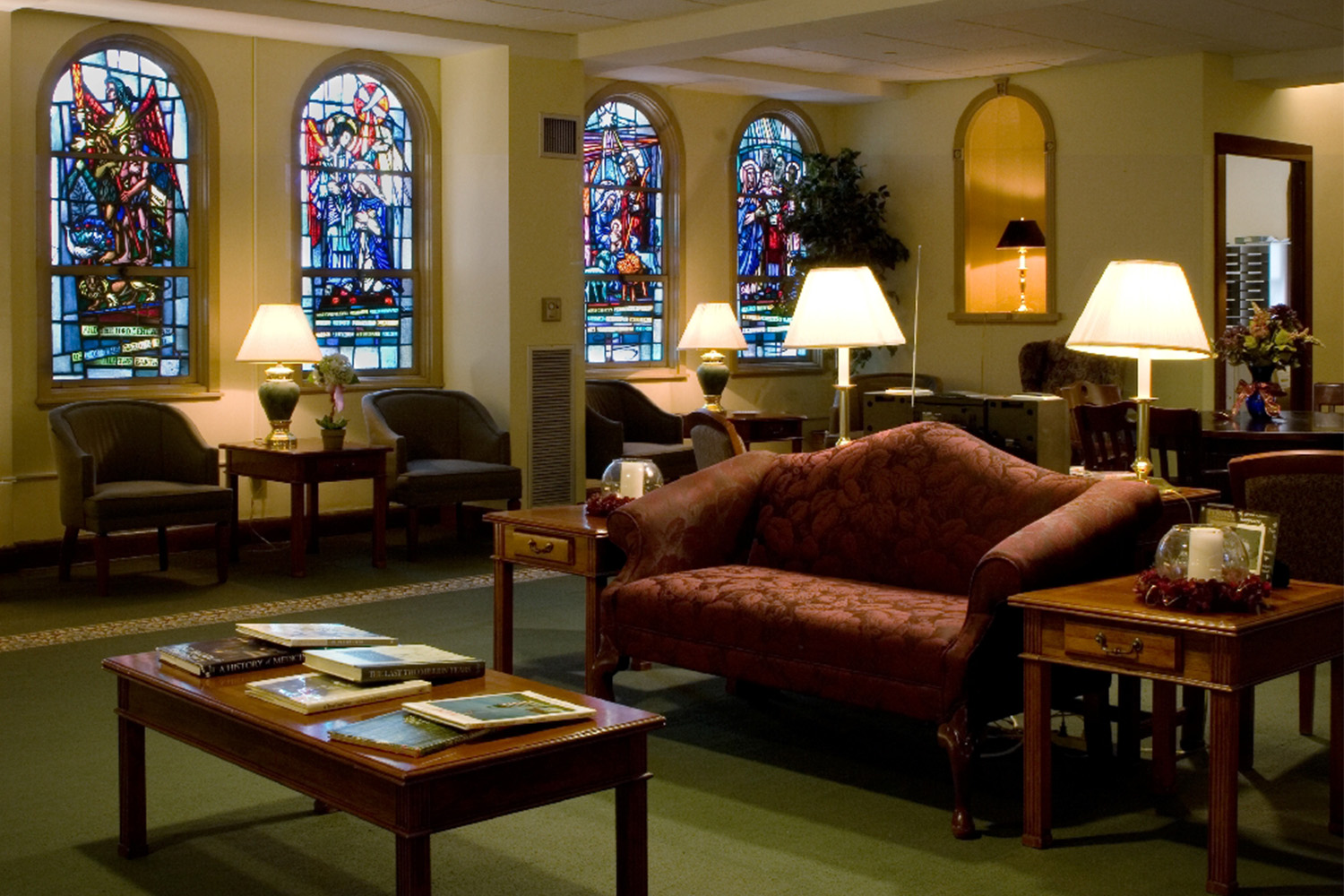 Lobby area with vintage red couch and stained glass windows