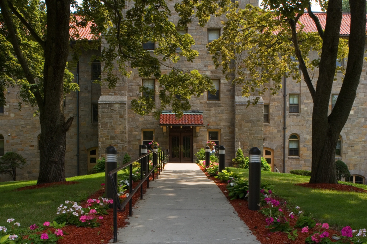 Walkway leading to chapel main entrance, with short black lamps on each side 