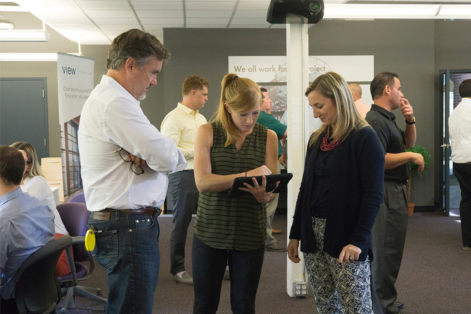 3 people overlooking an iPad