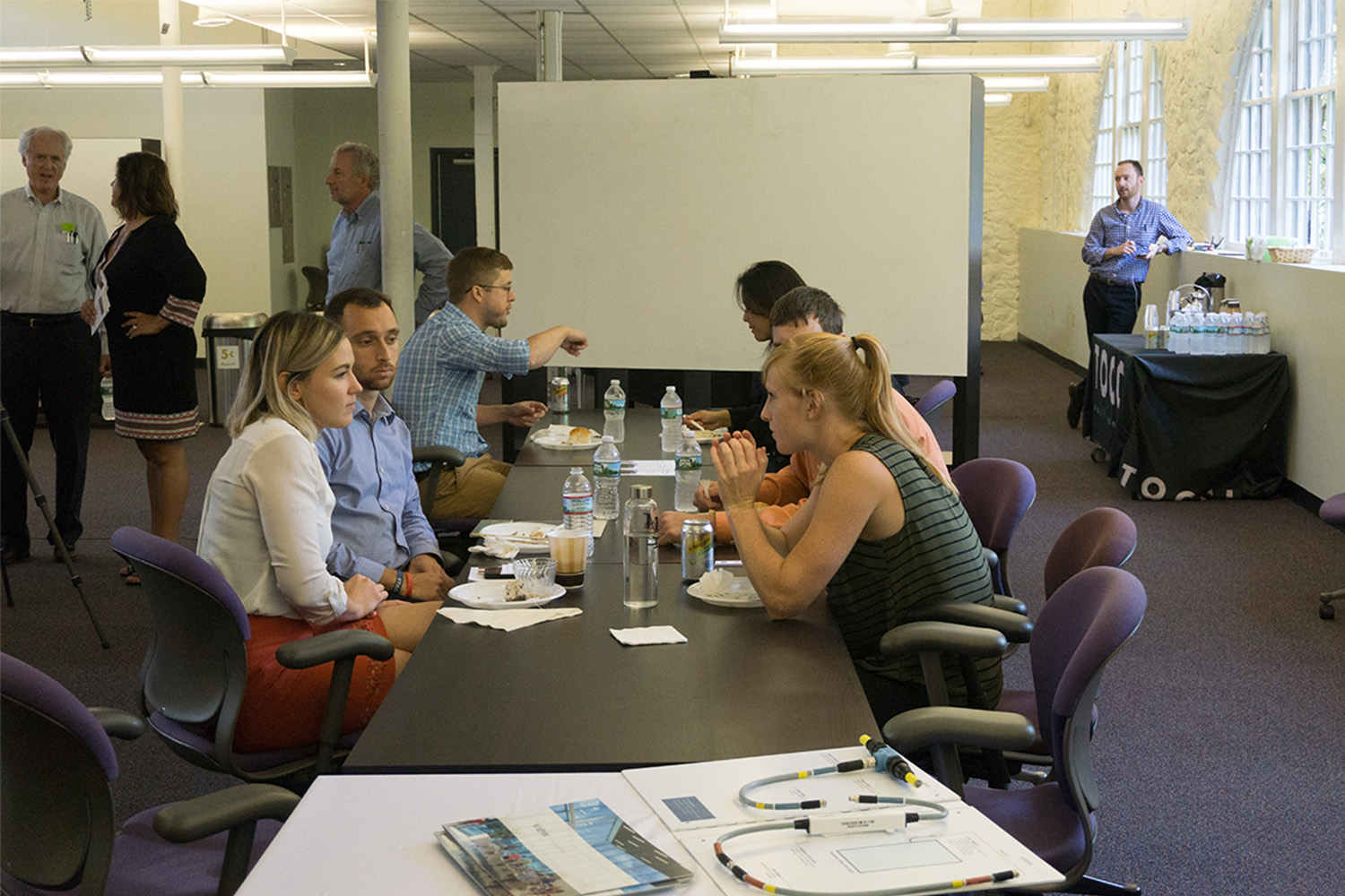 6 people talking as they sit by a long table