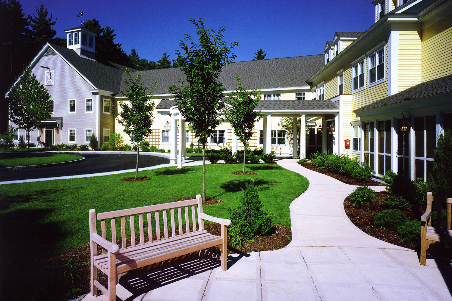 Walkway winding through neighborhood, with façade of townhouses in sight