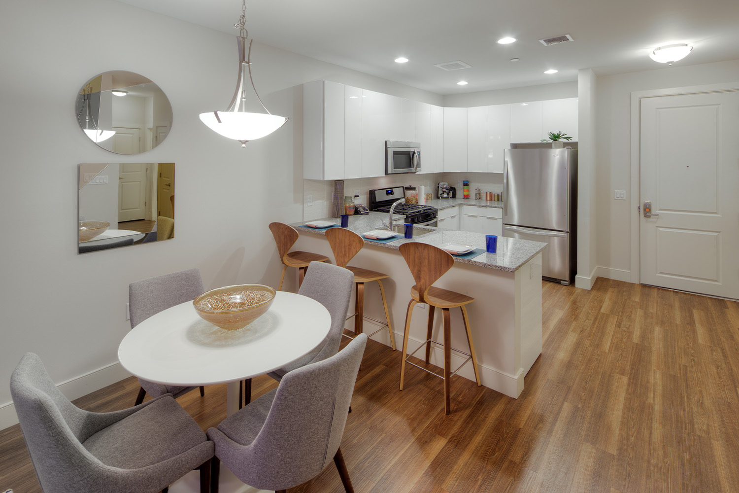 Elegant dining area with hanging wall sconce, and view of kitchen