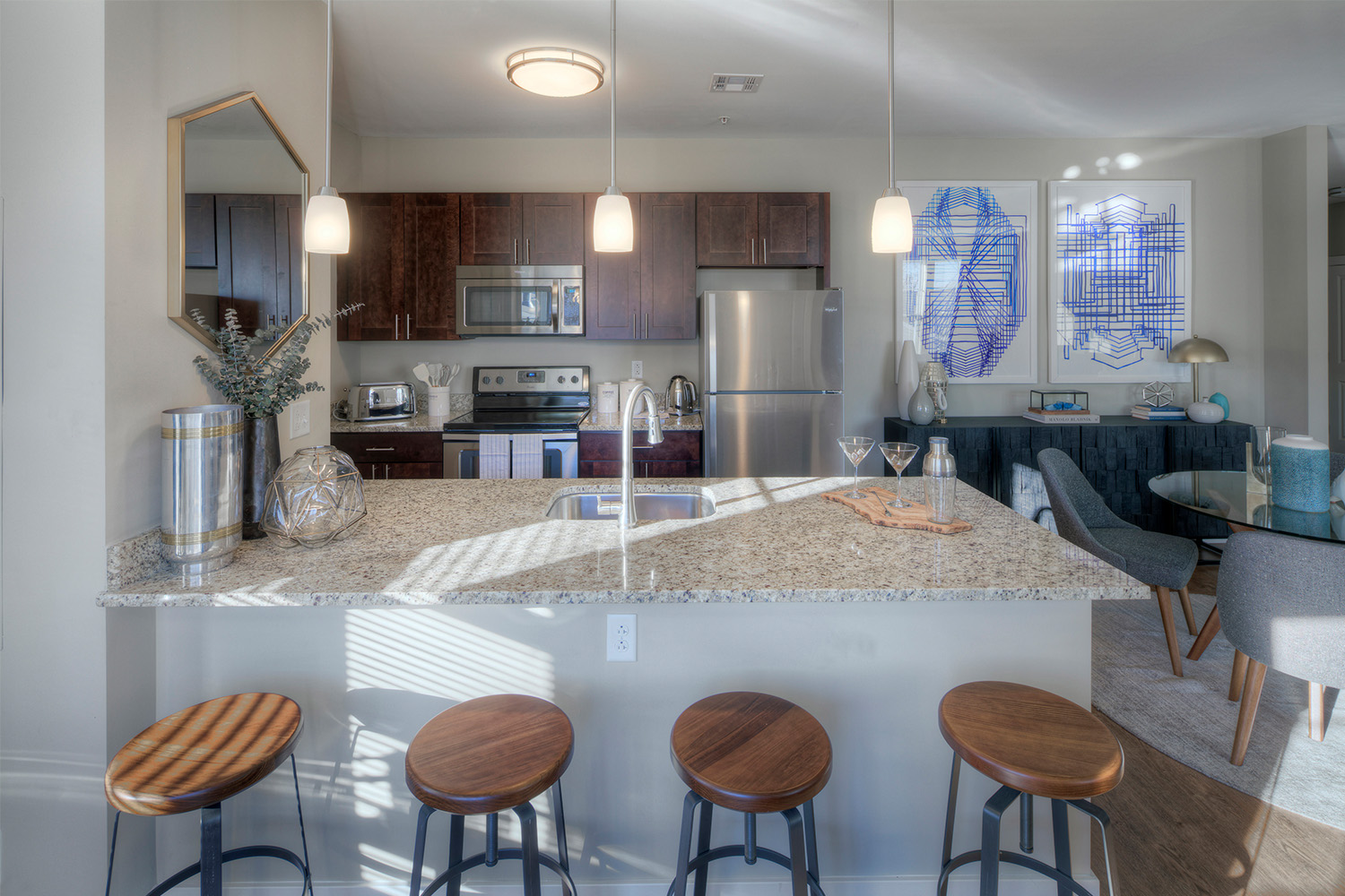 Kitchen with mahogany cabinets, oval shaped window, and bar area with white granite countertops 