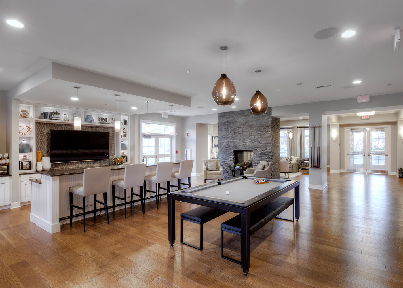 lobby area with fireplace, bar seating, and pool table 