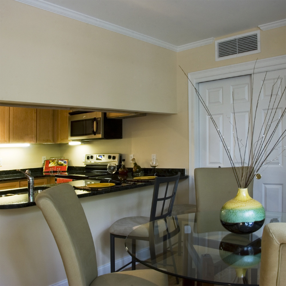 Dining room with glass table, view of kitchen from dining room 