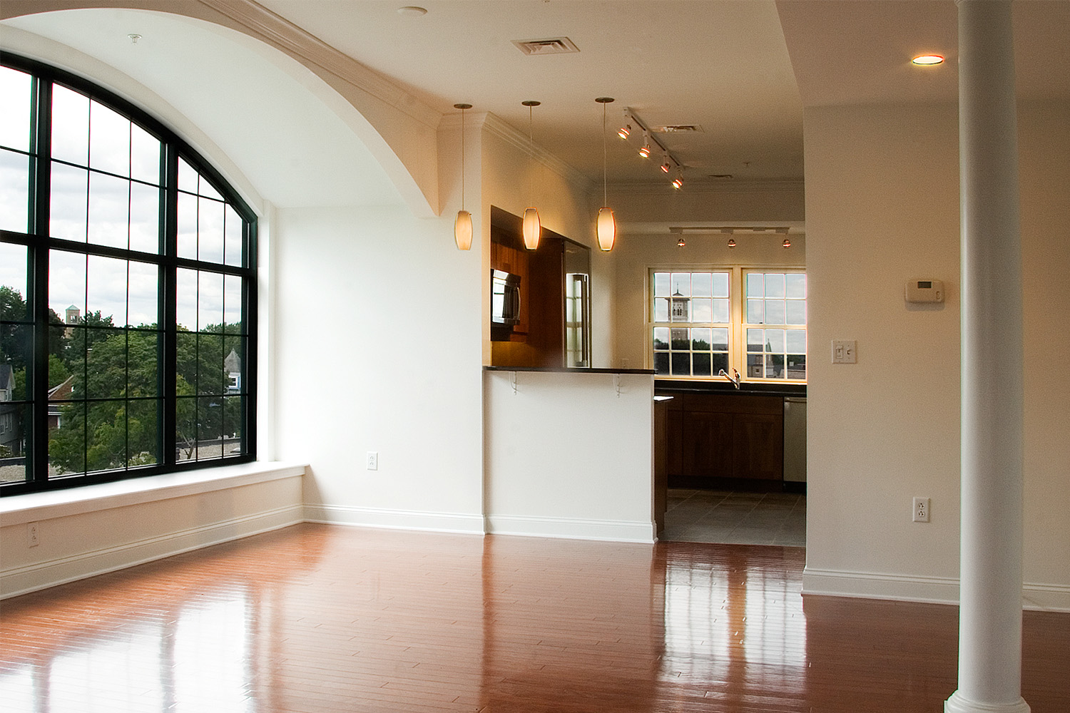 Spacious living area, with enormous window with arch overhead 