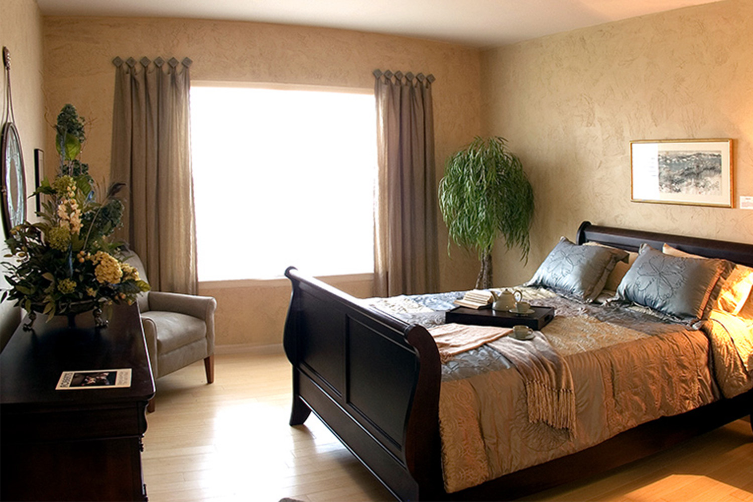 Warm bedroom with window allowing ample lighting, mahogany bedframe 