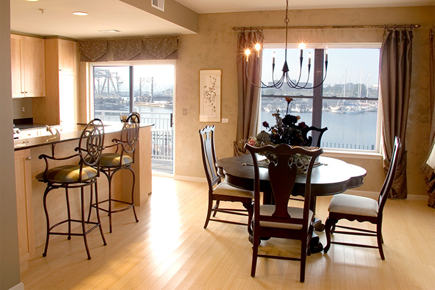 Bright dining room with sliding glass doors, and dark mahogany wood chairs and table 