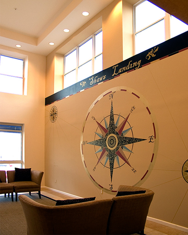 Reception area with small windows near ceiling, and compass design painted on wall 