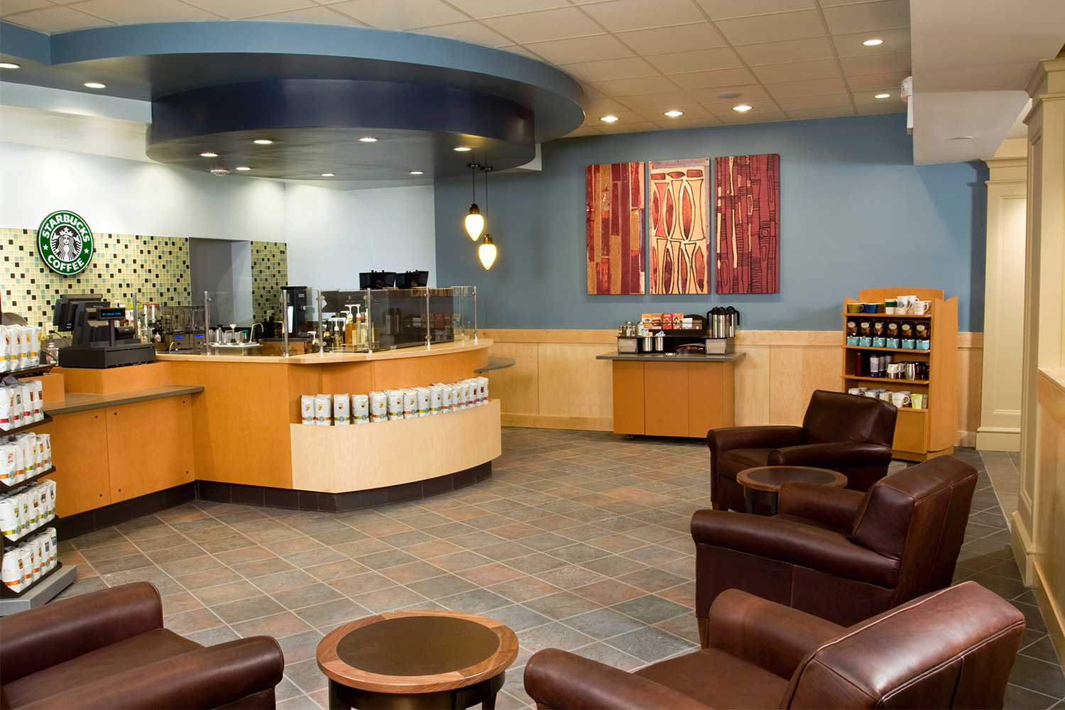 Starbucks café area with luxe brown leather chairs, tile floor, and blue painted walls 