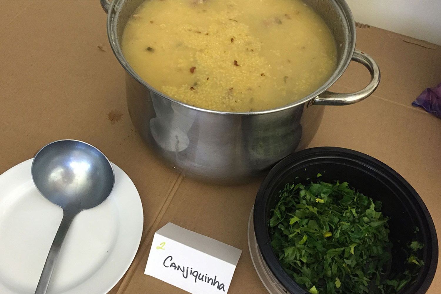 Freshly prepared bowl of canjiquinha soup with cilantro on the side