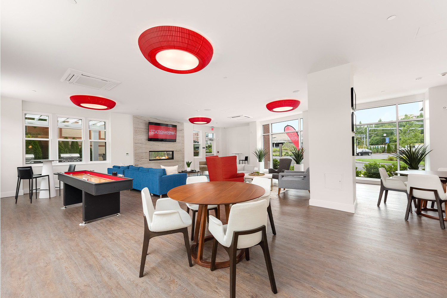 Bright living space with retro red light fixtures, pool able, and seating 