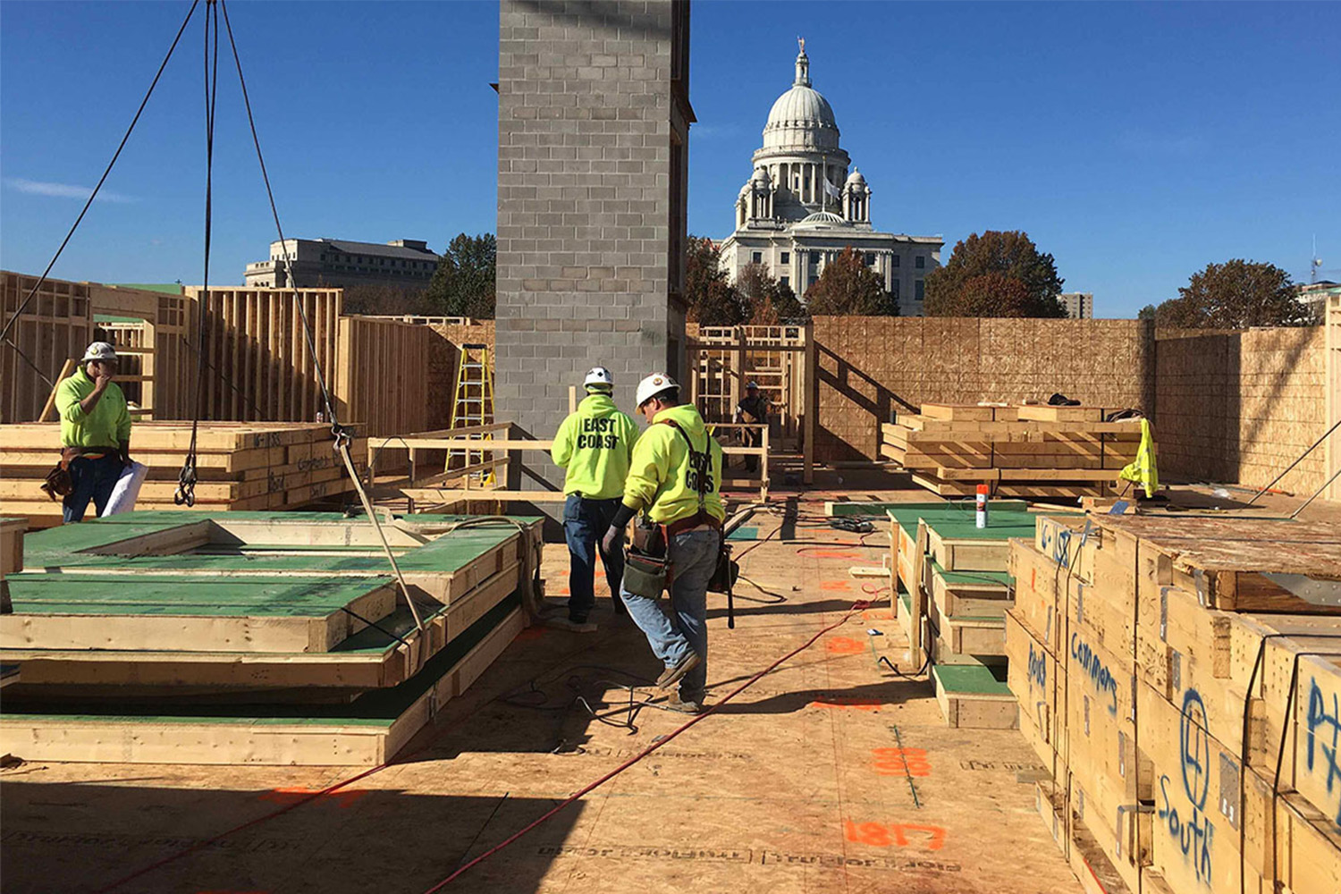 Construction workers walking on top of roof 