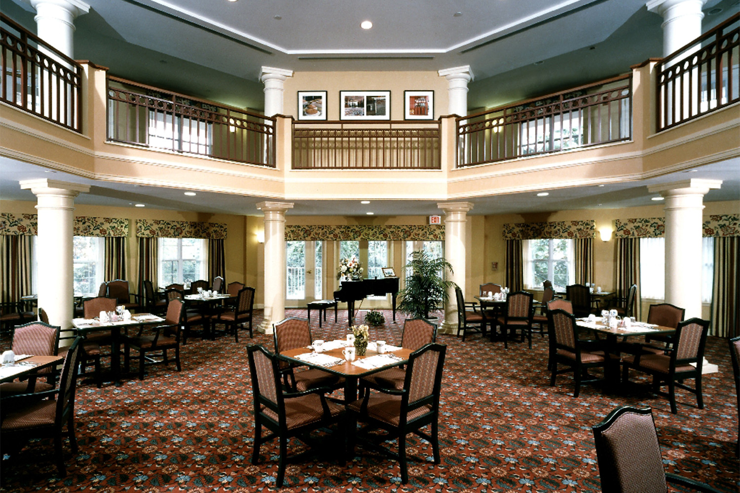 Octagonal dining room, with wooden chairs and tables, and windows on every wall