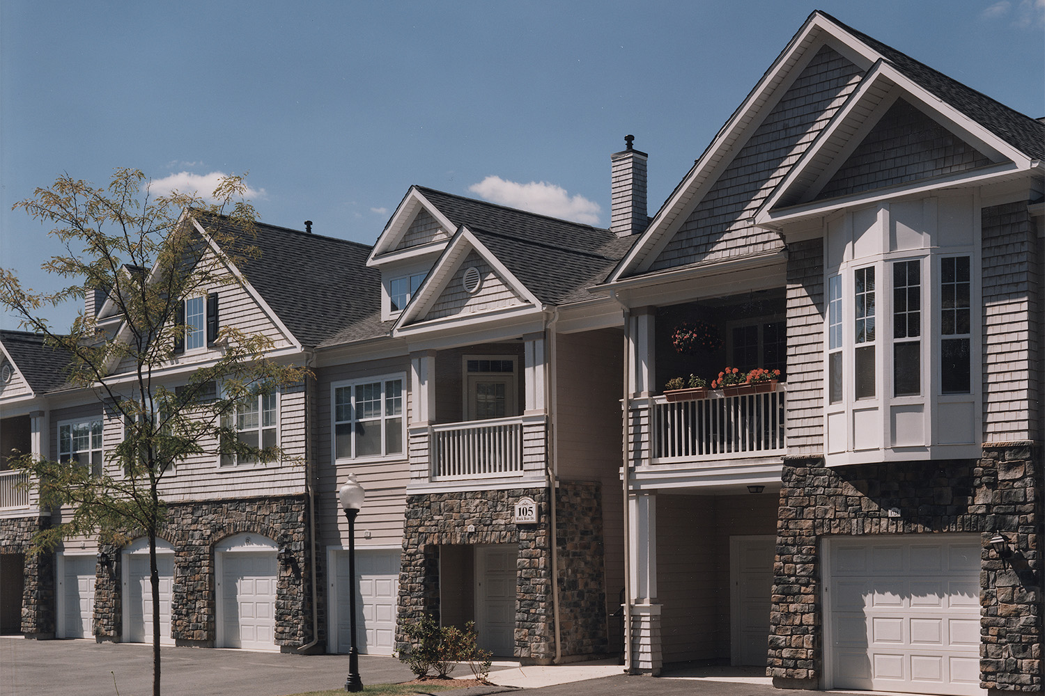 Row of townhouses seen at an angle, with trees in front 