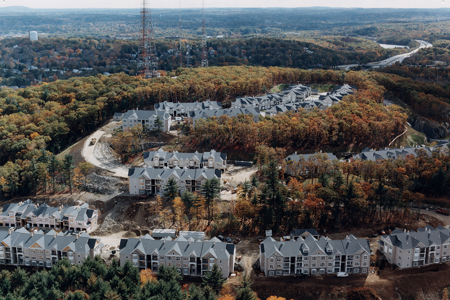 Drone view of houses surrounded by autumn trees 