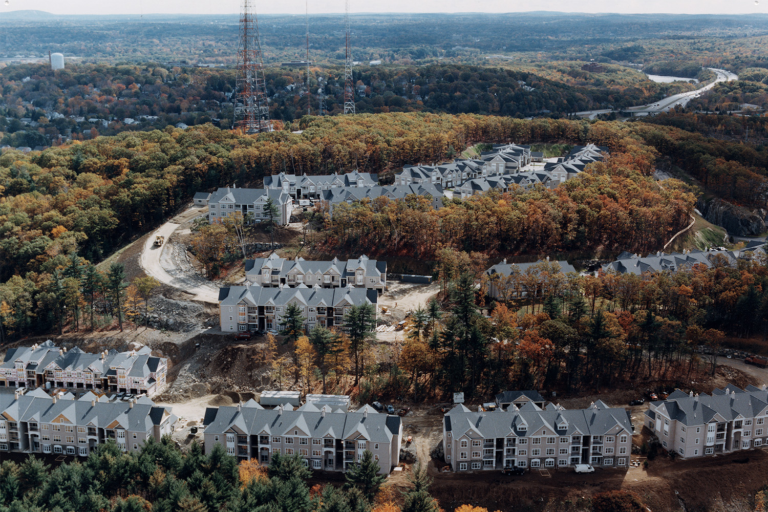 Drone view of houses surrounded by autumn trees