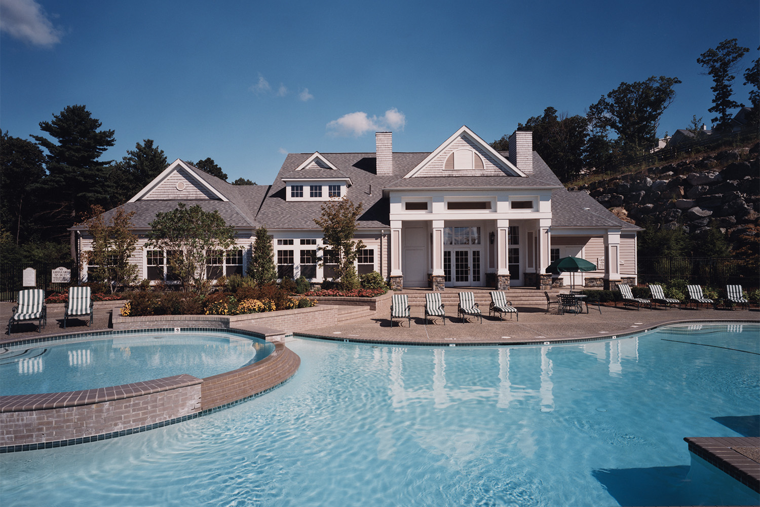 Clean blue outdoor pool with lounge chairs 