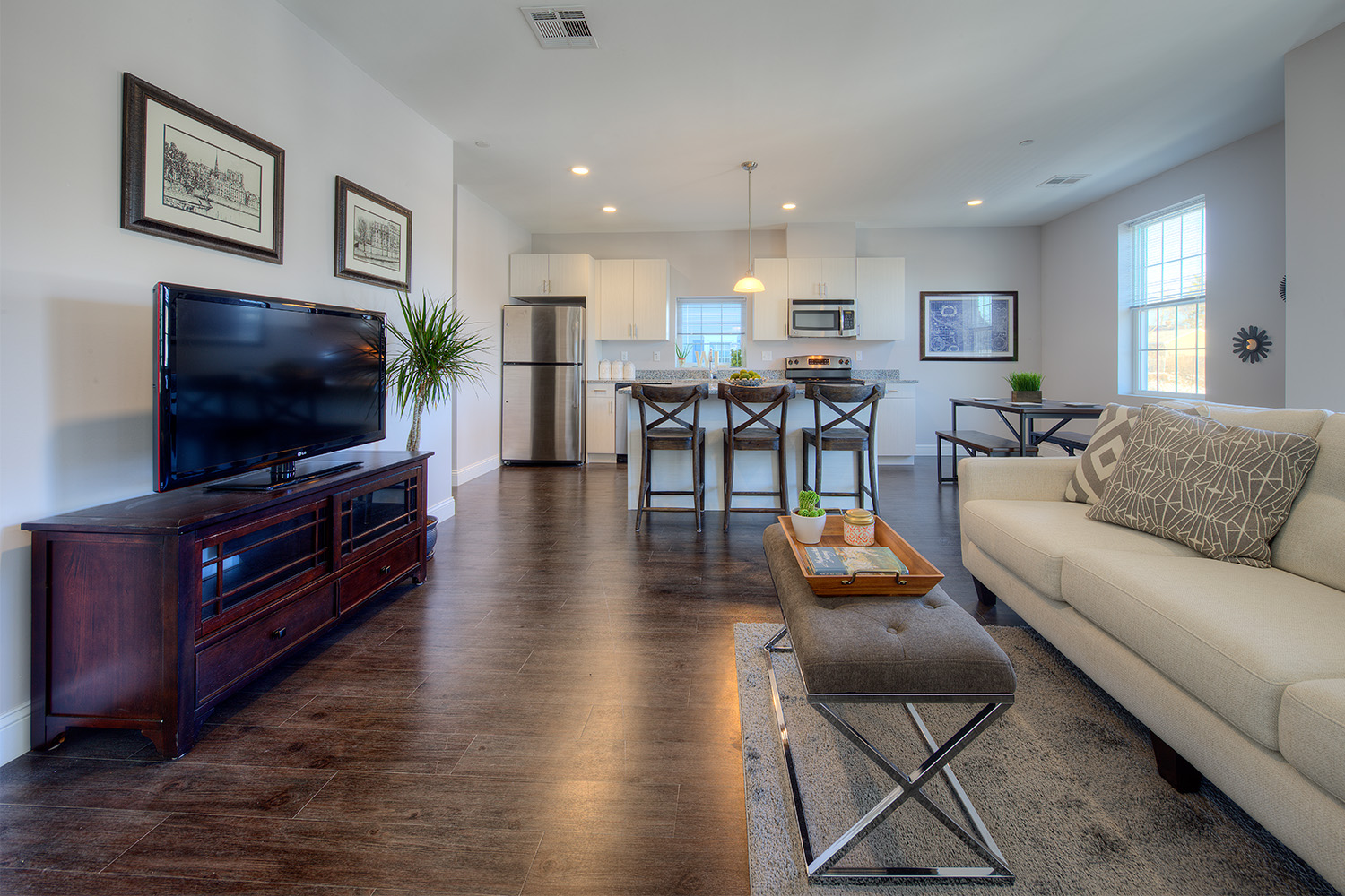 Sideview of living room with soft couch and TV across from kitchen