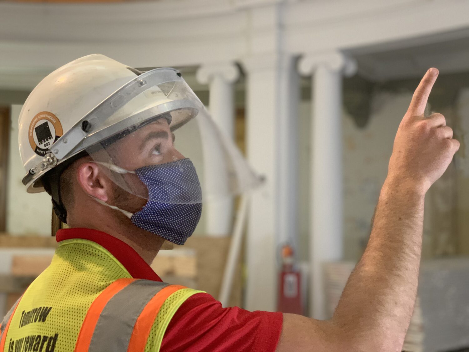 Superintendent, Brendan Clifford, points up towards the ceiling during a project site walk-through