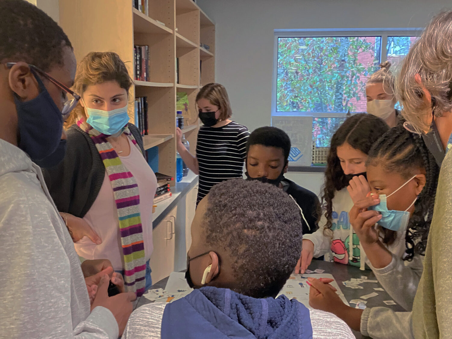 Project Manager, Zeina Habib, works with kids at the Boys & Girls Club during an exercise about the construction cycle during Careers in Construction Month