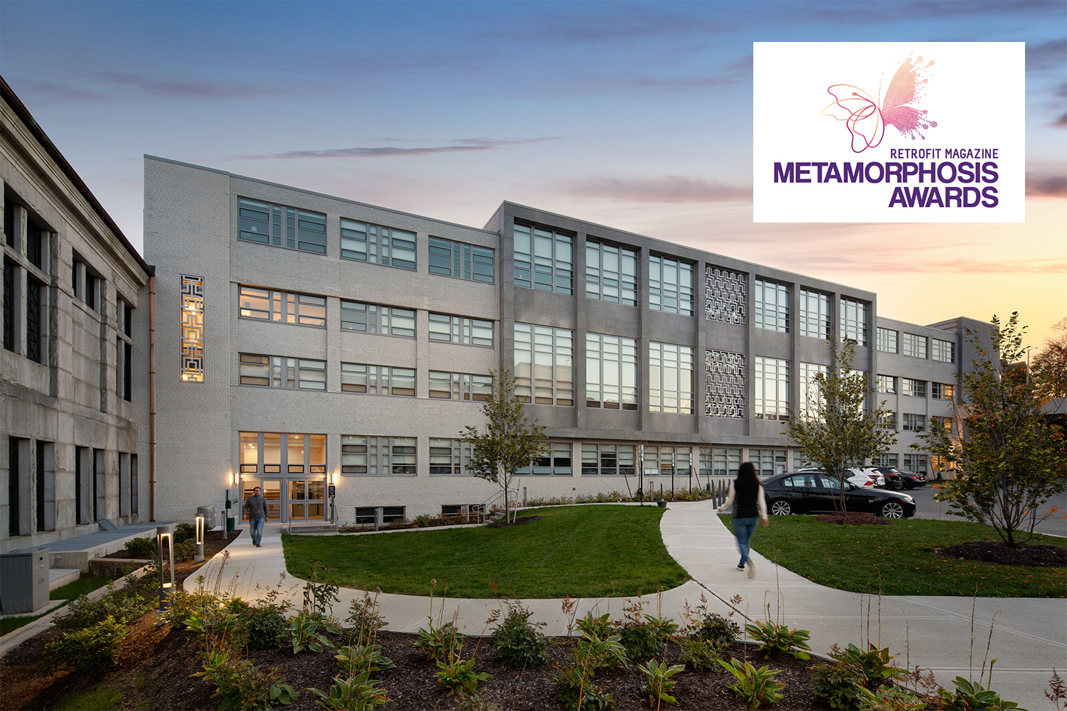 Final photography of Courthouse Lofts, with woman walking into the Loft's Annex section. Retrofit Magazine's Metamorphosis award logo sits in the top right corner.