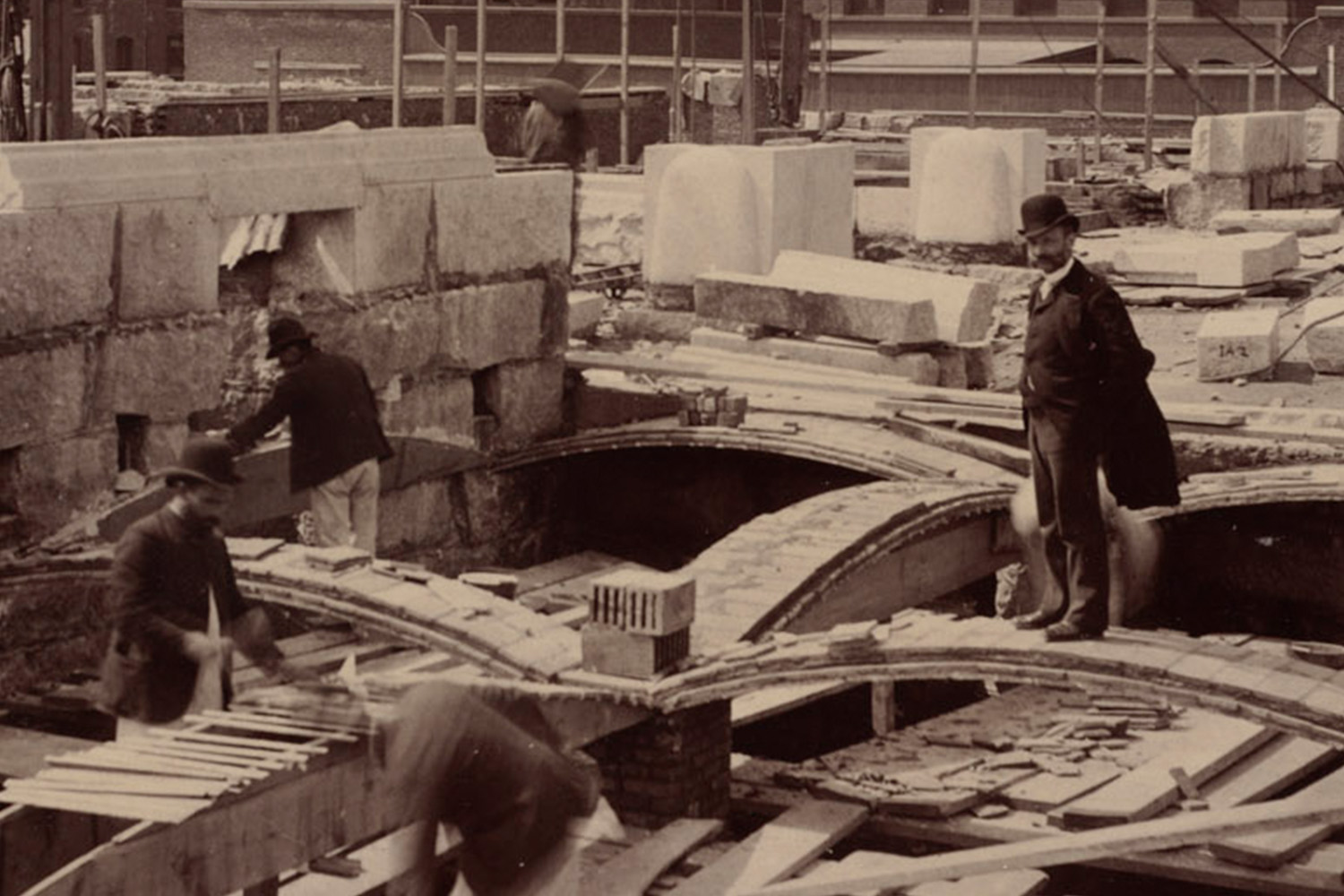 Rafael Guastavino stands on recently laid tile arch along Boylston Street during construction of the McKim Building