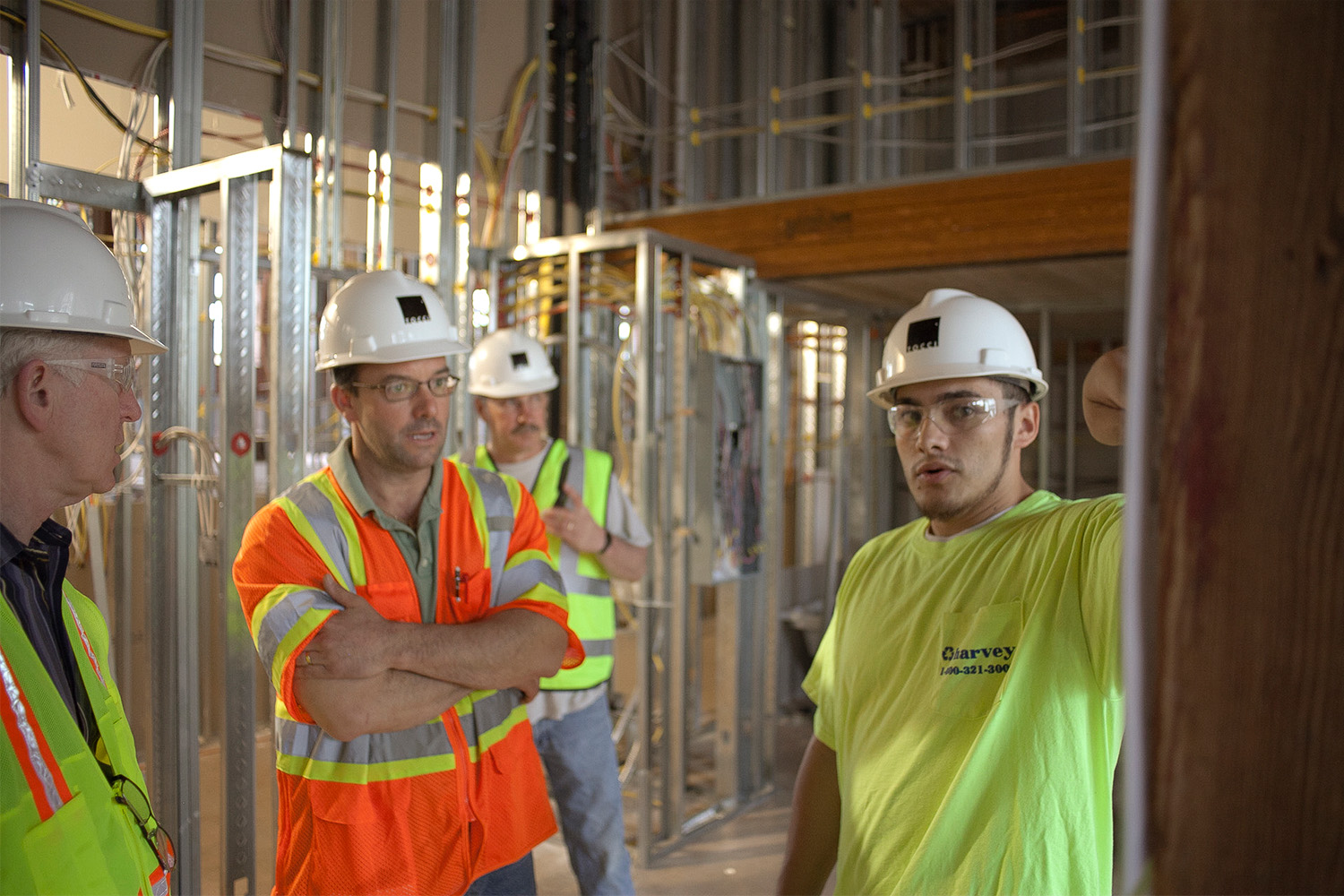 Tocci employees wearing PPE, as they discuss logistics at the construction site 