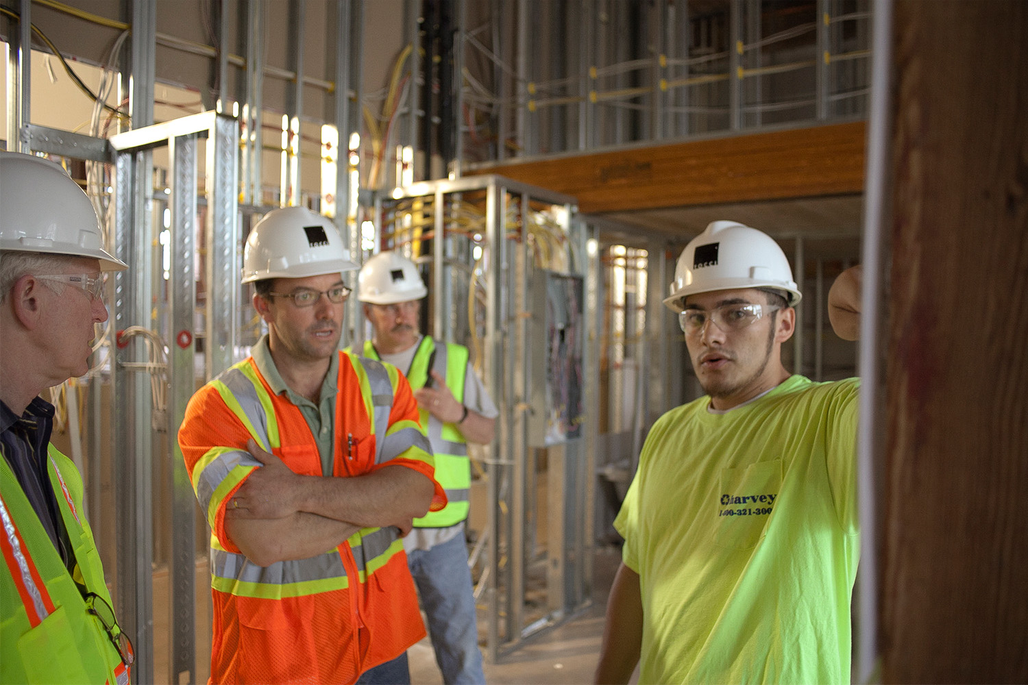 Tocci employees wearing PPE, as they discuss logistics at the construction site