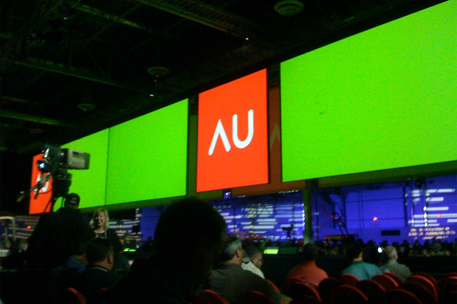 several monitors hanging from wall, saying "AU" 