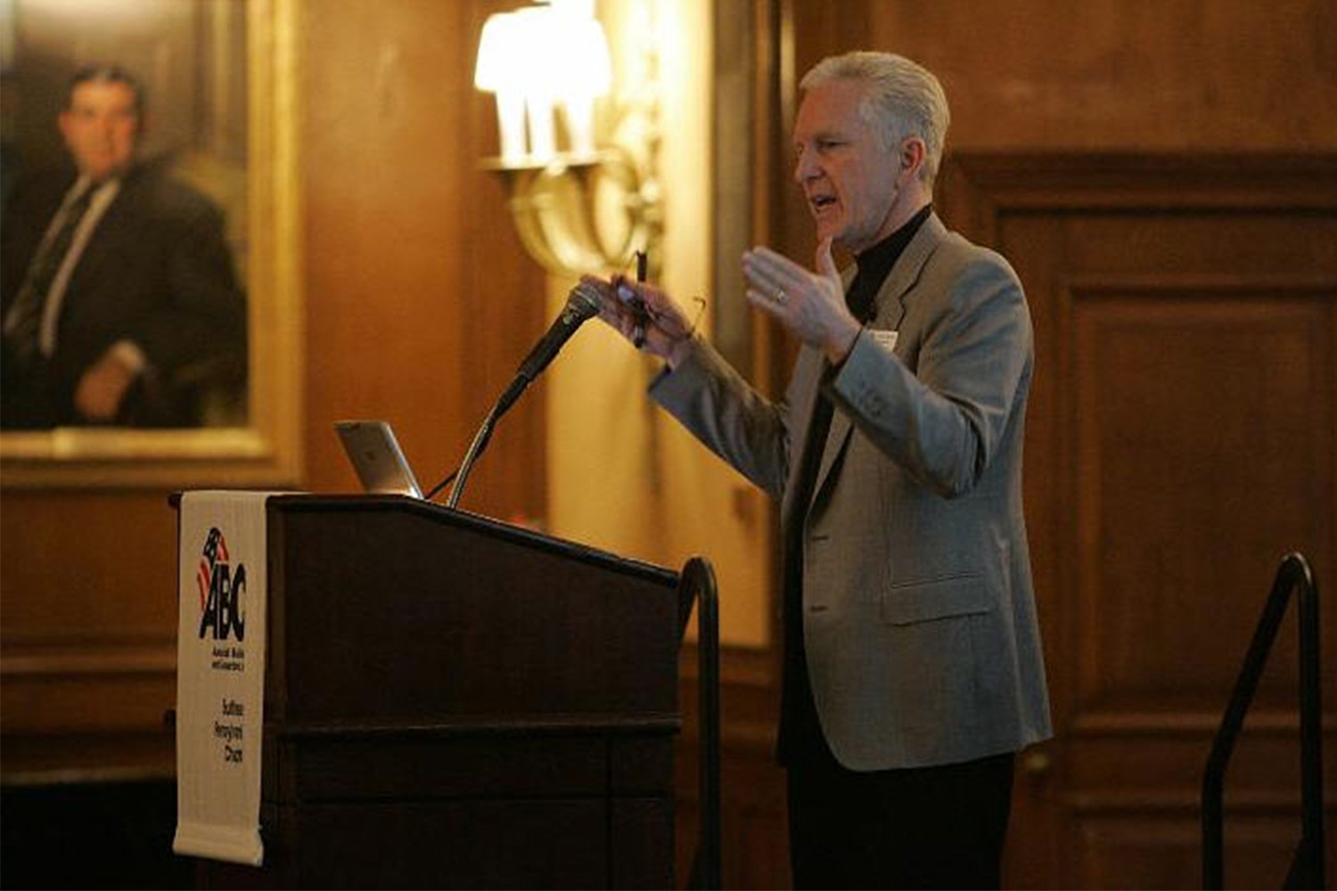 John Tocci giving keynote address while standing behind podium 