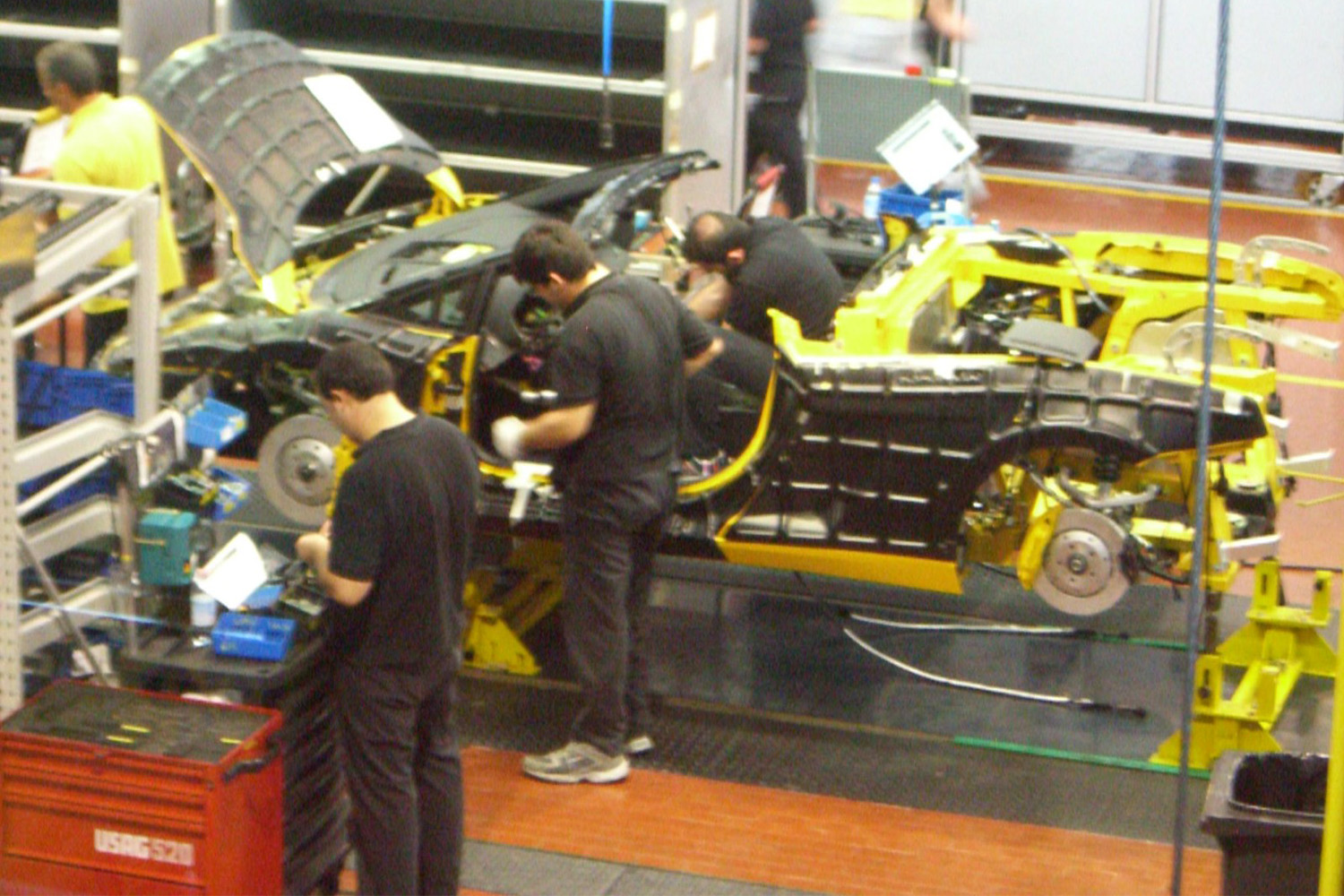 Mechanics at the Lamborghini factory working on assembling a car 