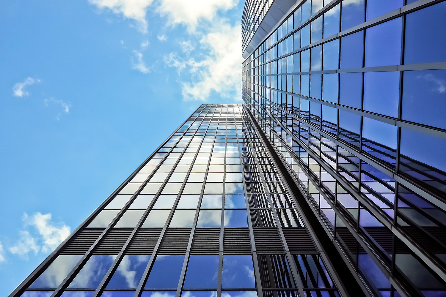 worm's eye view of skyscraper with glazed glass panels 