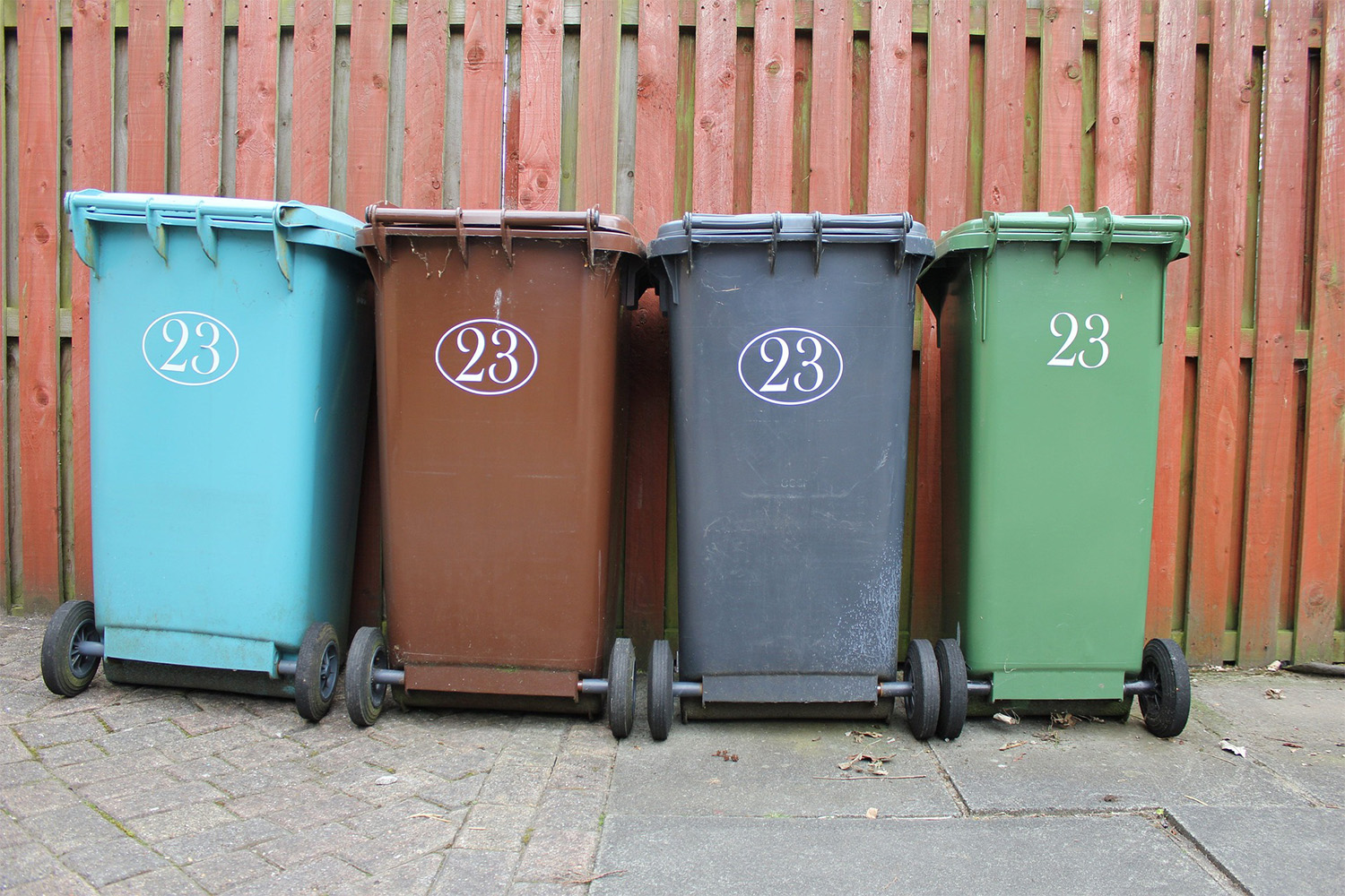 recycle bins in front of fence