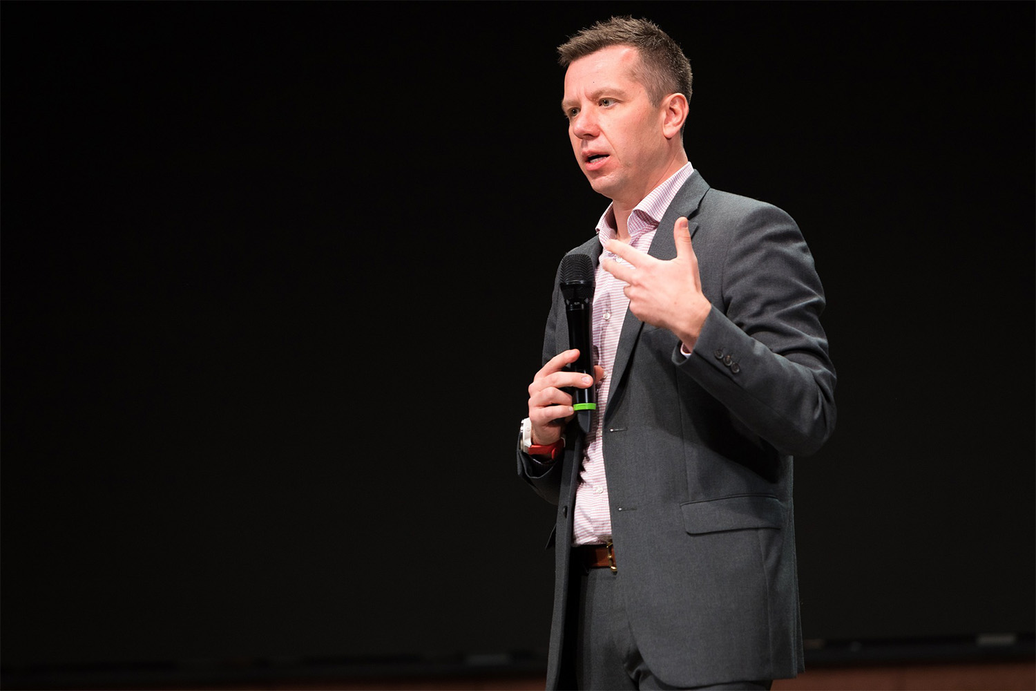 man using microphone speaking to the audience 