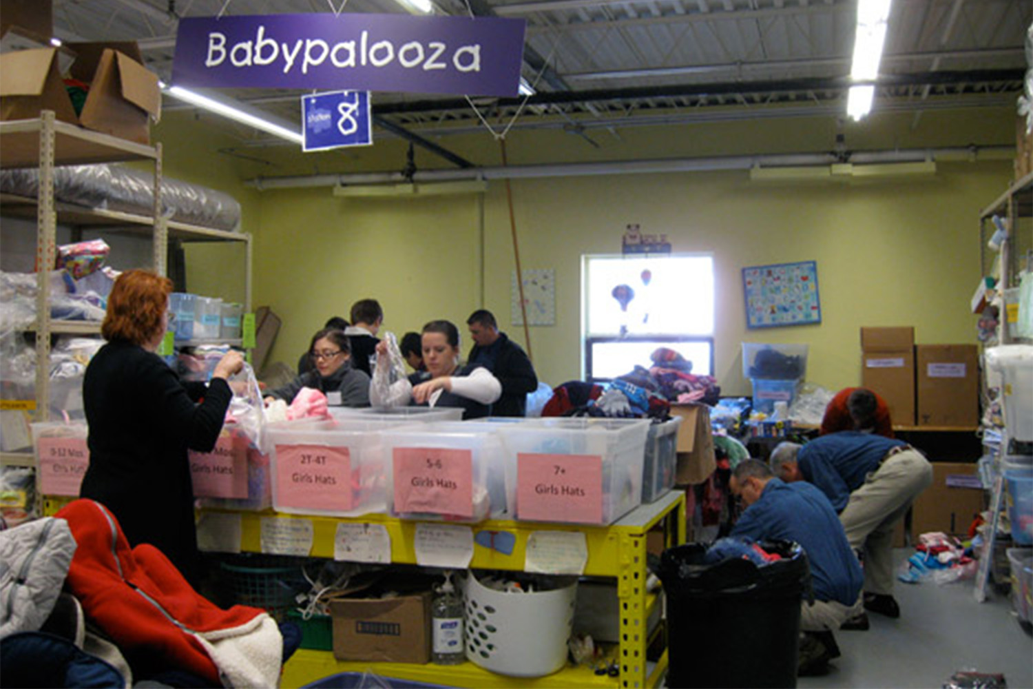 Tocci volunteers sorting through cloths at the "babypalooza" section 