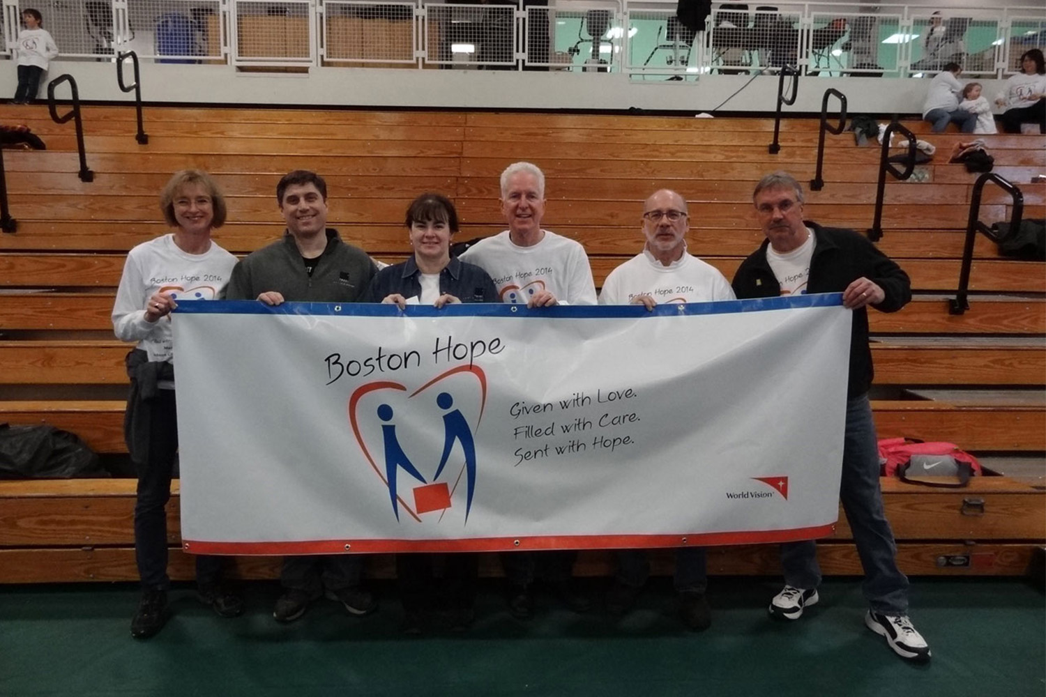 Tocci Boston hope volunteers, posing for phot while holding "Boston Hope" banner